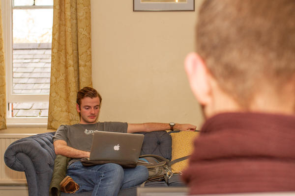 Photo of a Wycliffe student on his laptop in the Upper Common Room