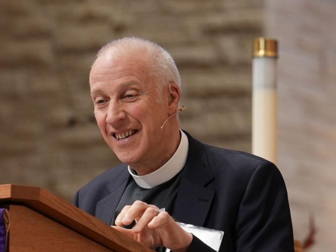 An image of MichaeL Lloyd standing at a lectern preaching