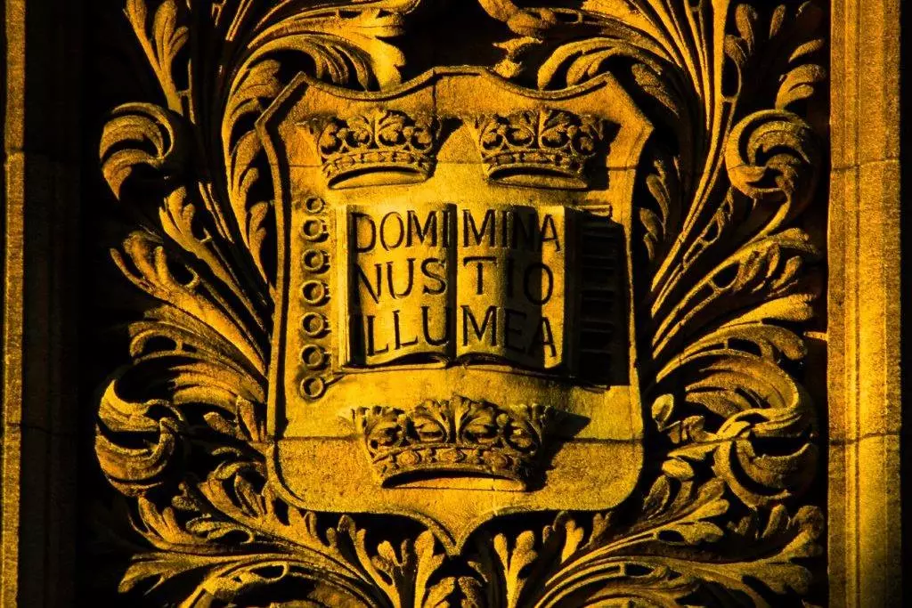 Sun drenched University shield with motto